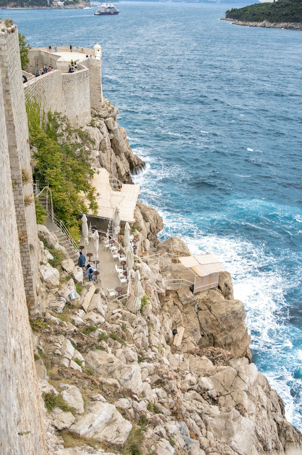 un muro de piedra con una pasarela de piedra y un cuerpo de agua