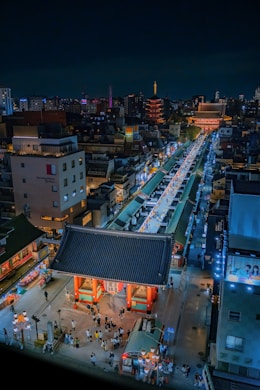 a city with a large crowd of people and buildings at night