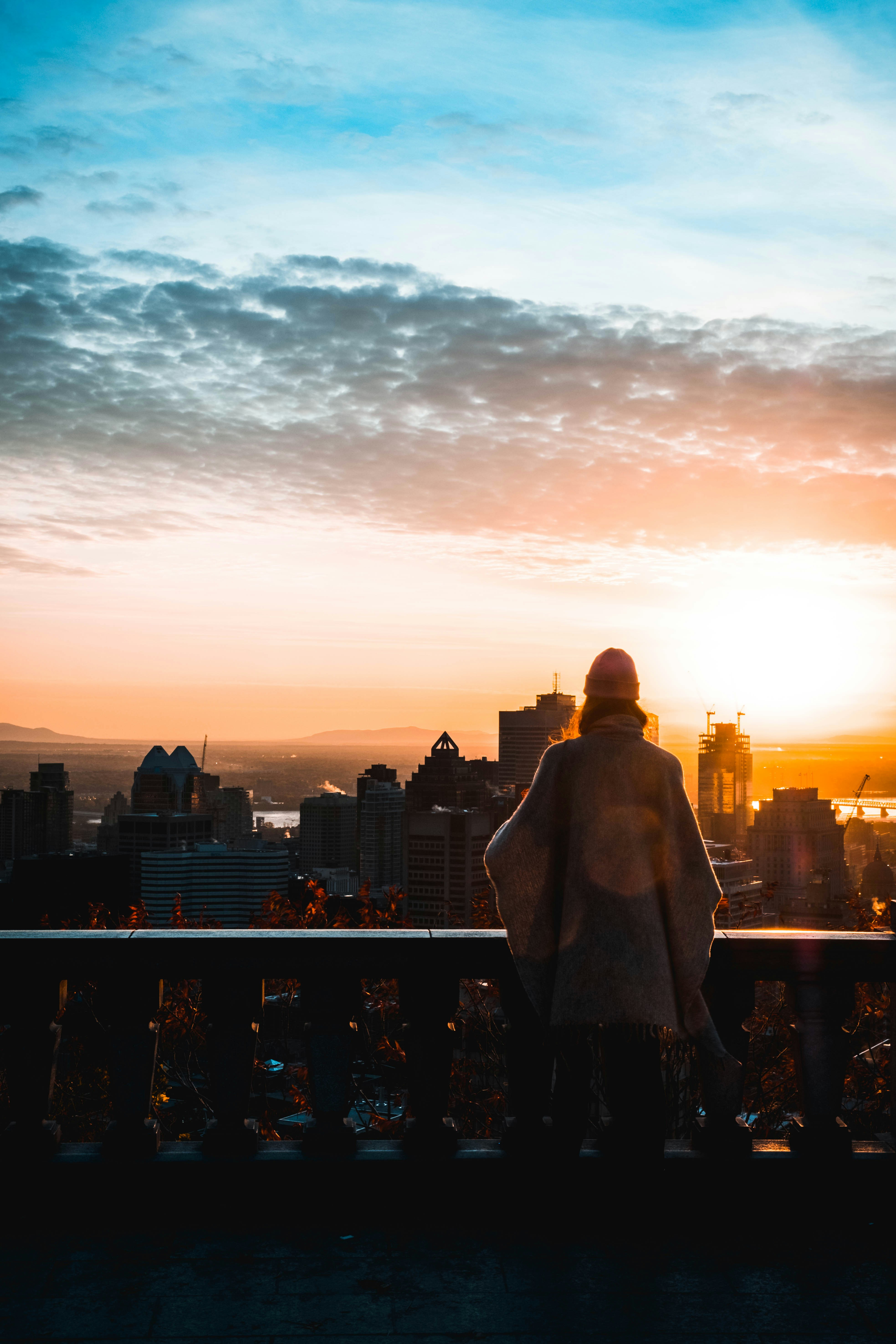 a person standing on a balcony looking at a city