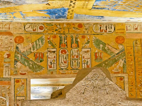 A detailed close-up of an ancient Egyptian fresco showing vibrant hieroglyphs and figures.