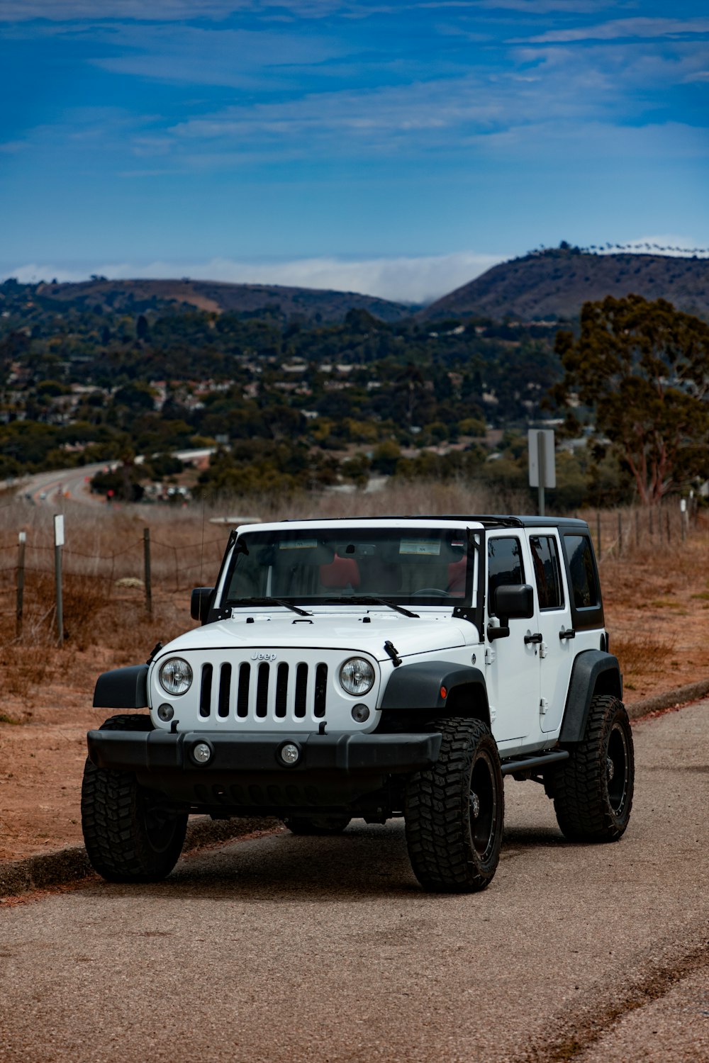 a white jeep on a dirt road
