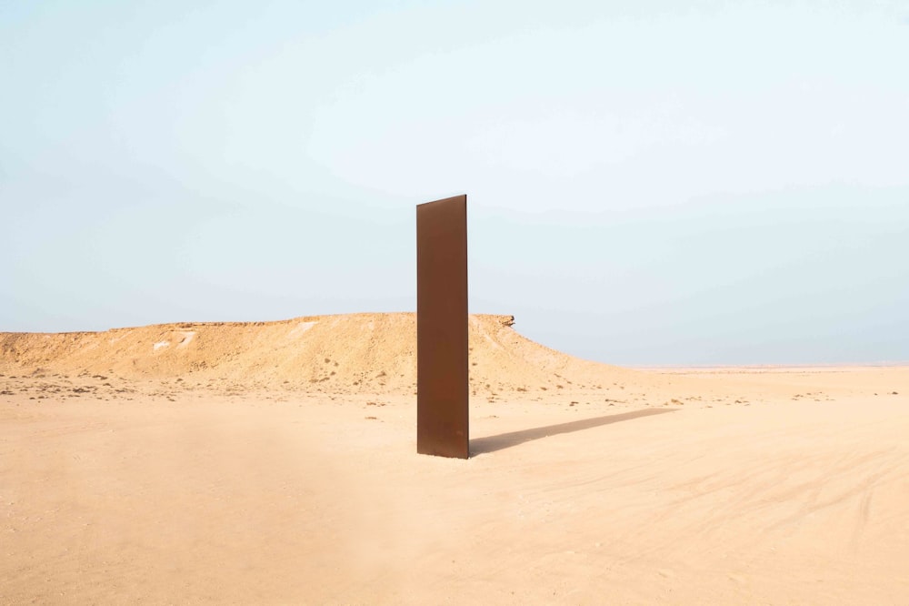 a tall wooden structure in the middle of a desert