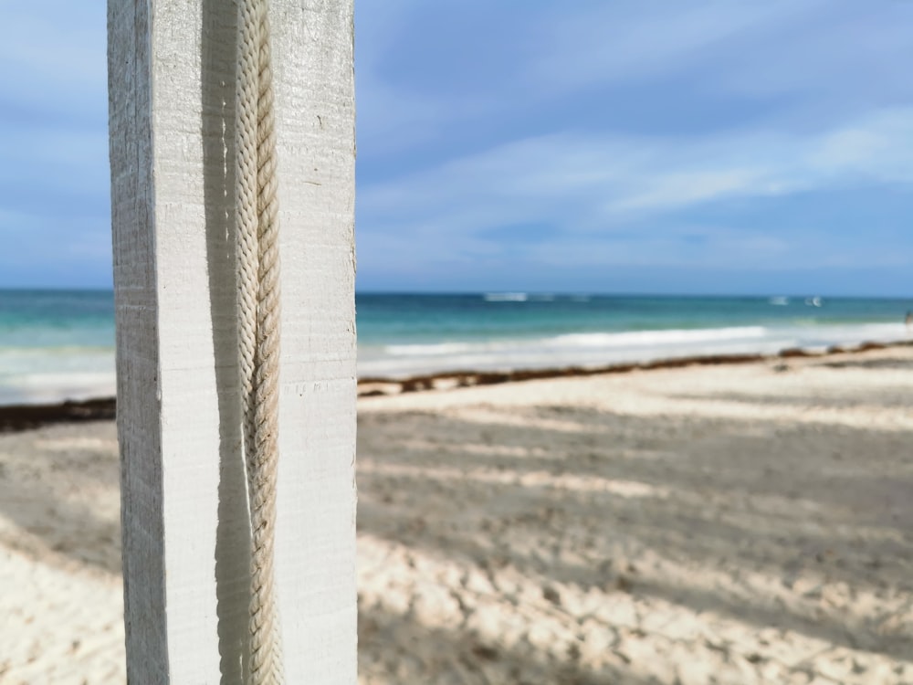 a white post on a beach