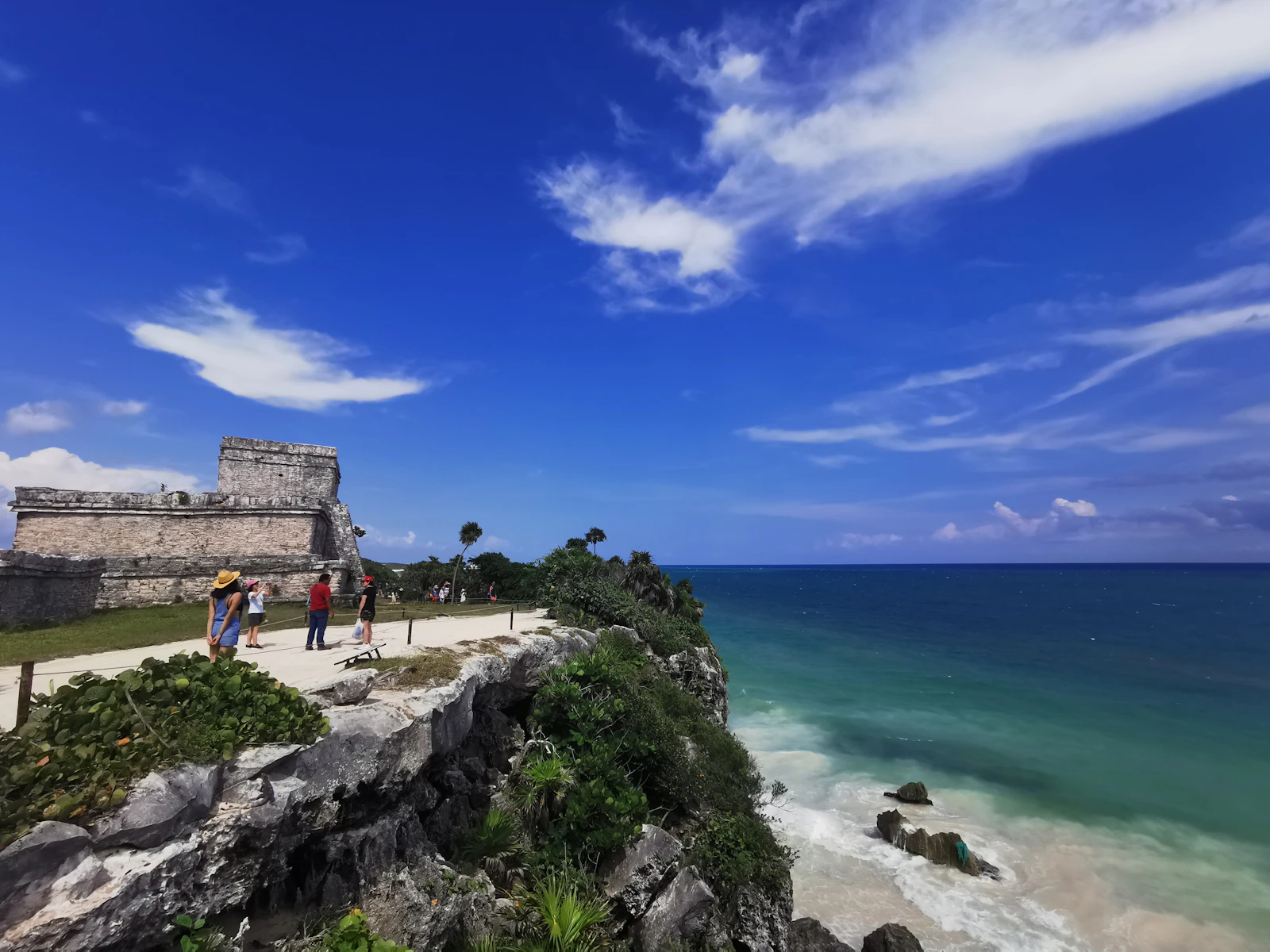 tantra massage in Tulum — people walking along a seaside path