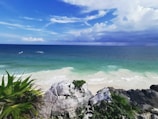 a rocky beach with a body of water in the background