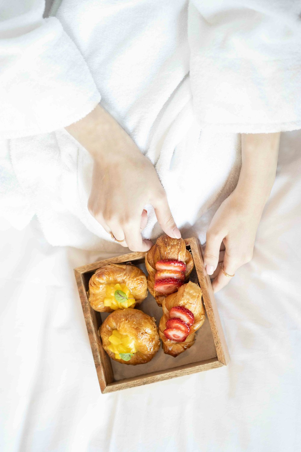 une personne tenant une boîte de beignets