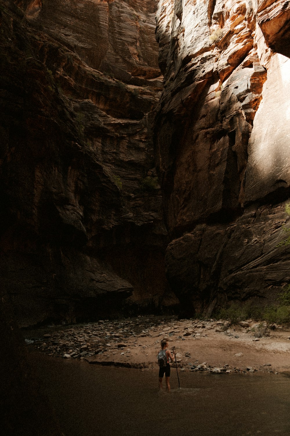 a person standing in a river between large rocks