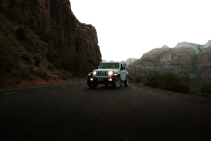A Jeep parked on a mountain overlook with a panoramic view of valleys below