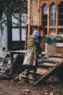 a person in a hat and scarf standing next to a pile of wood