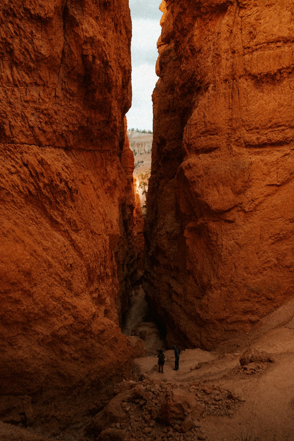 people walking between large rocks