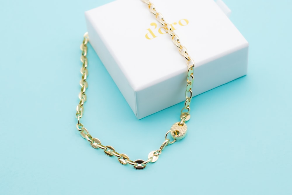 a white box with gold chain