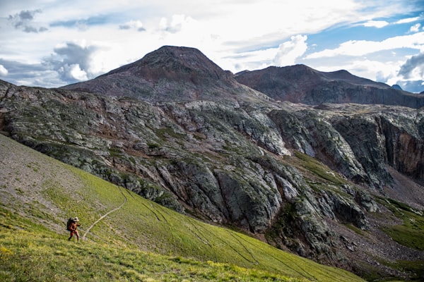 Backpacker hiking up a mountain trail