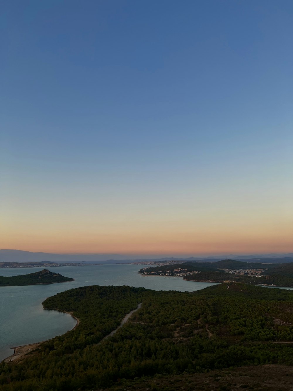 a landscape with a body of water and land with a road