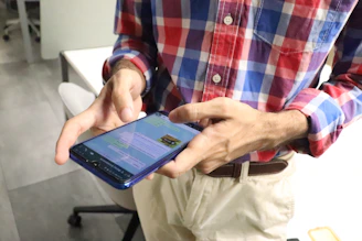 Business owner happily checking messages on a smartphone with navy and gray background.