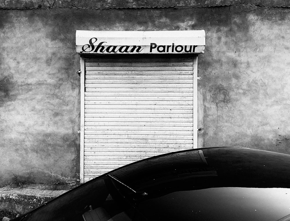 a car parked in front of a building with a sign on it