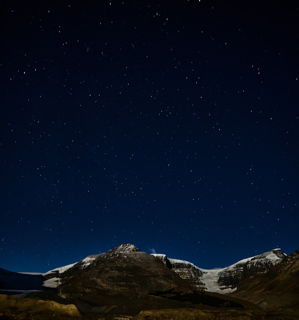 a snowy mountain and stars in the sky
