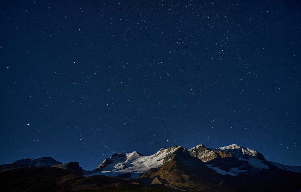 a snowy mountain with a starry sky above