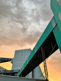 An outdoor shot of a large-scale industrial structure under construction at sunset.