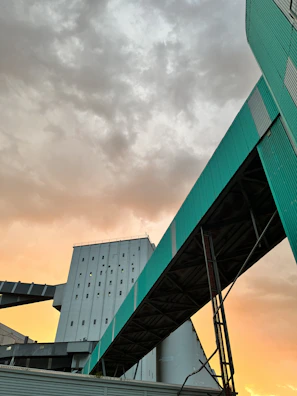 An outdoor shot of a large-scale industrial structure under construction at sunset.