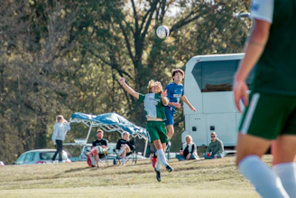 Action shot of players from Team One contesting a header