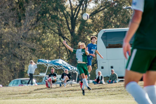 Action shot of players from Team One contesting a header
