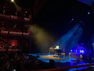 Softly lit stage with a piano and microphone ready for a live music evening.