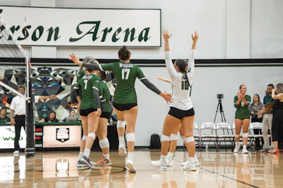 A group of volleyball players wearing matching personalized jerseys during a local tournament.