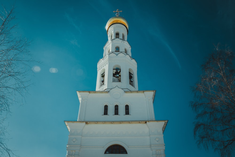 a white building with a gold domed roof and a cross on top