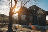 An old abandoned house with broken windows at dusk.