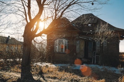 An old abandoned house with broken windows at dusk.