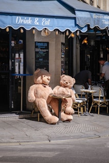 a couple of teddy bears sit on a sidewalk