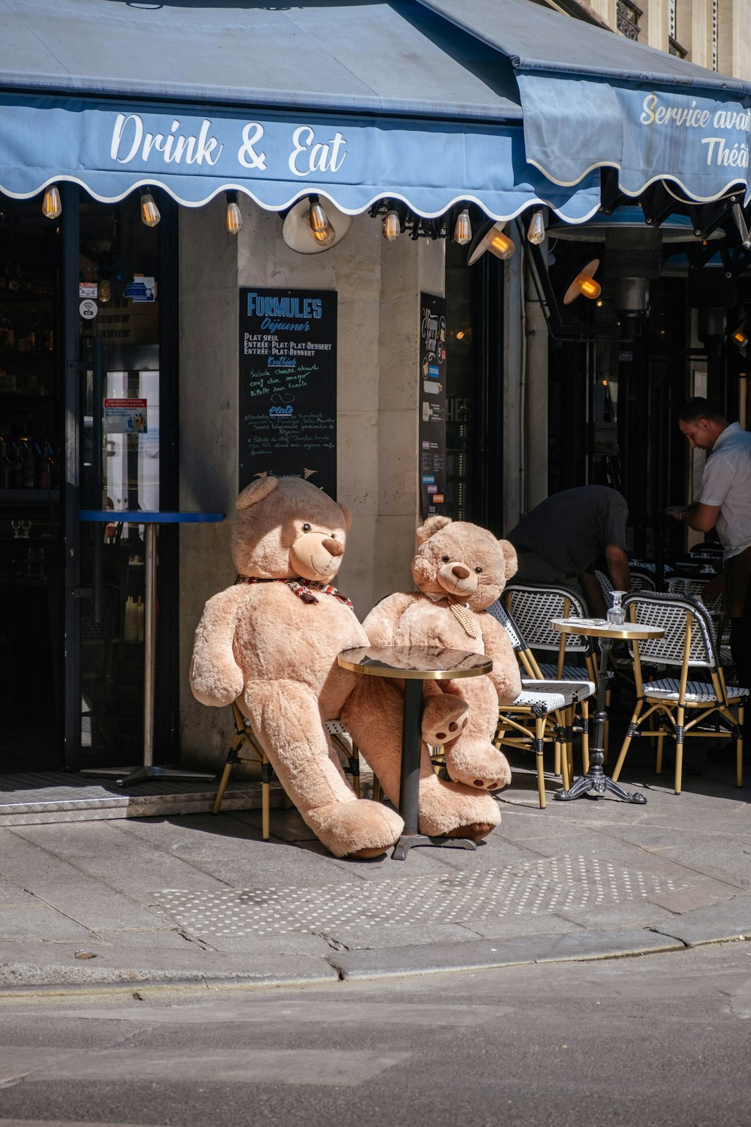 a couple of teddy bears sit on a sidewalk