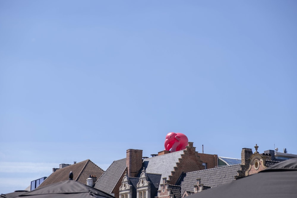 un ballon rouge flottant au-dessus d’un toit