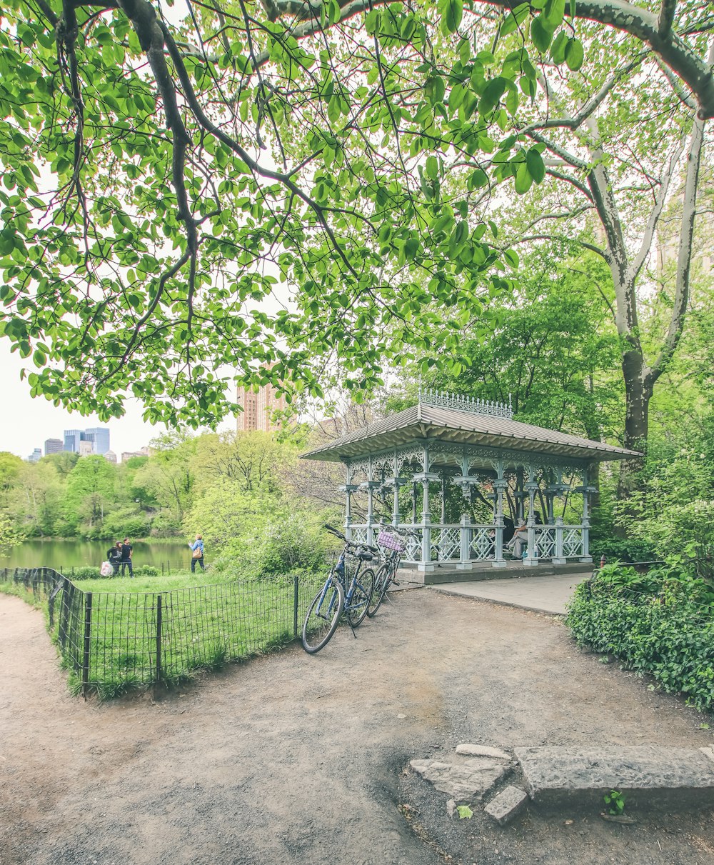 a small building with a fence and trees around it