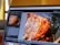 A laptop screen displaying Adobe Lightroom Classic software with a close-up image of a cooked piece of meat being edited. The interface shows various editing options and a navigation panel on the left side.