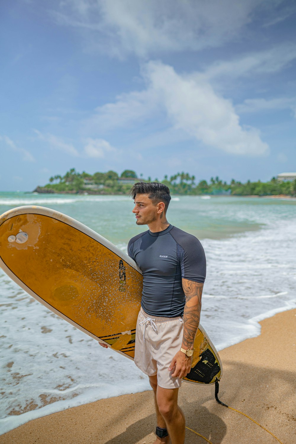 Un homme tenant une planche de surf