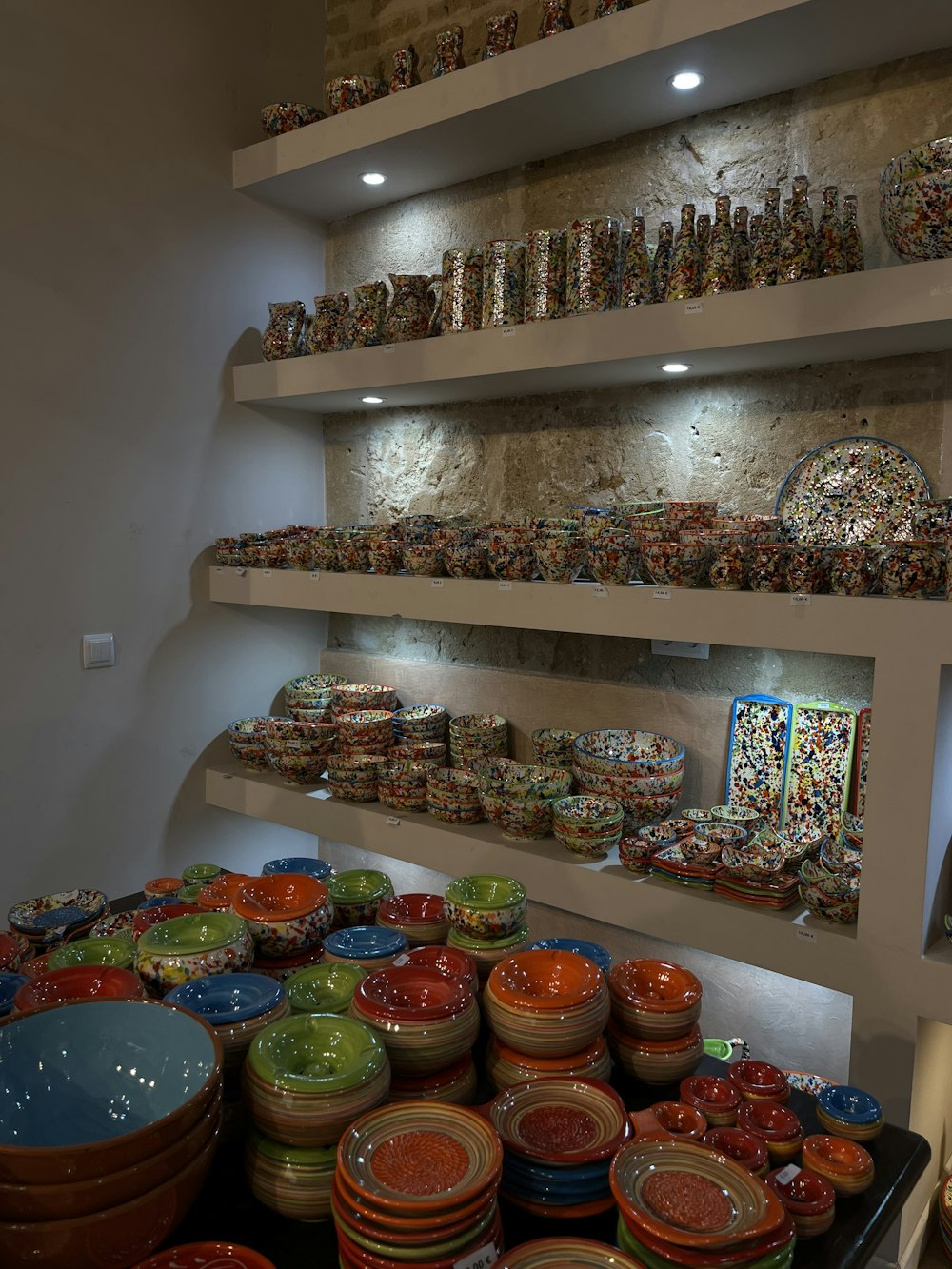 a shelf with many plates and bowls on it