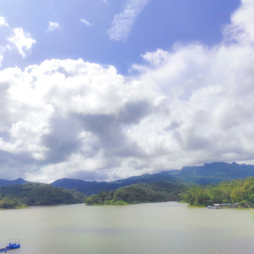 a body of water with trees and mountains in the background