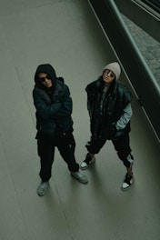 two people standing on a sidewalk