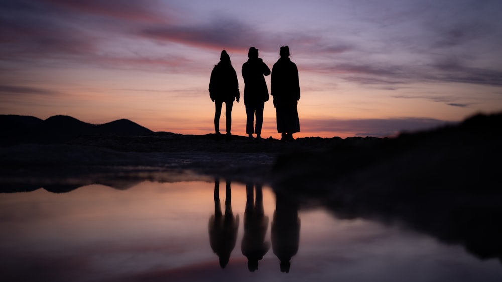 a group of people standing on a beach