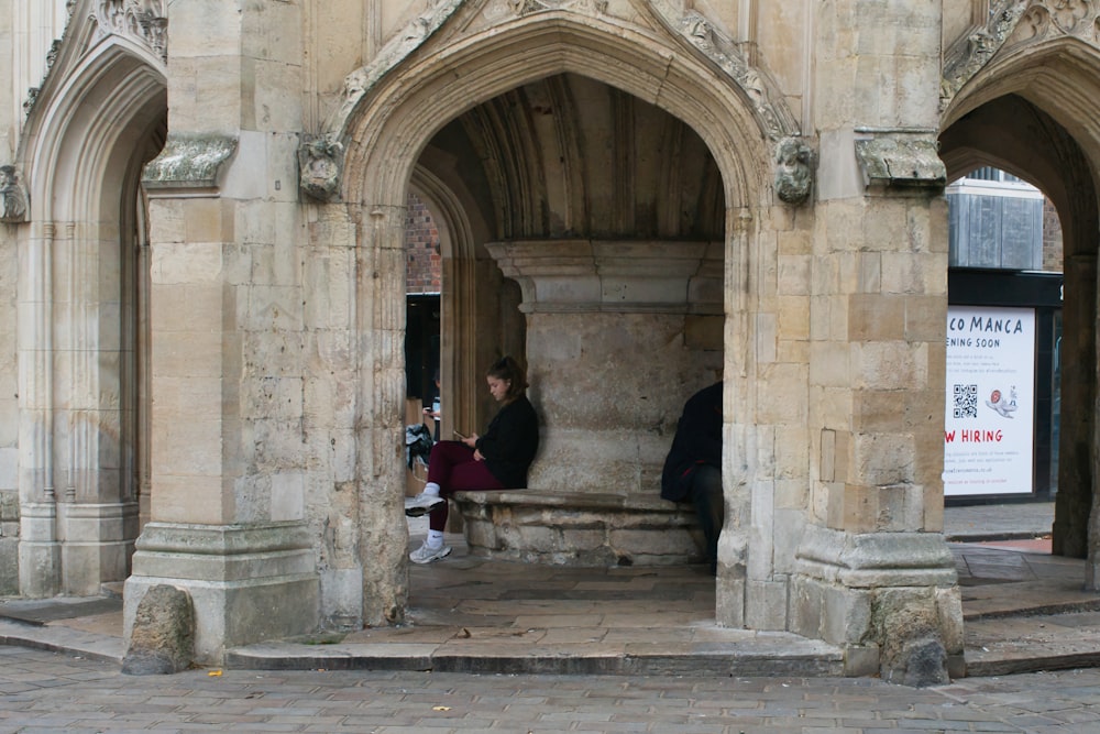 a man and a woman sitting on a bench in a building