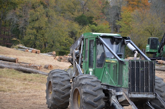 A rugged mulching machine clearing dense underbrush on a sunny hillside.