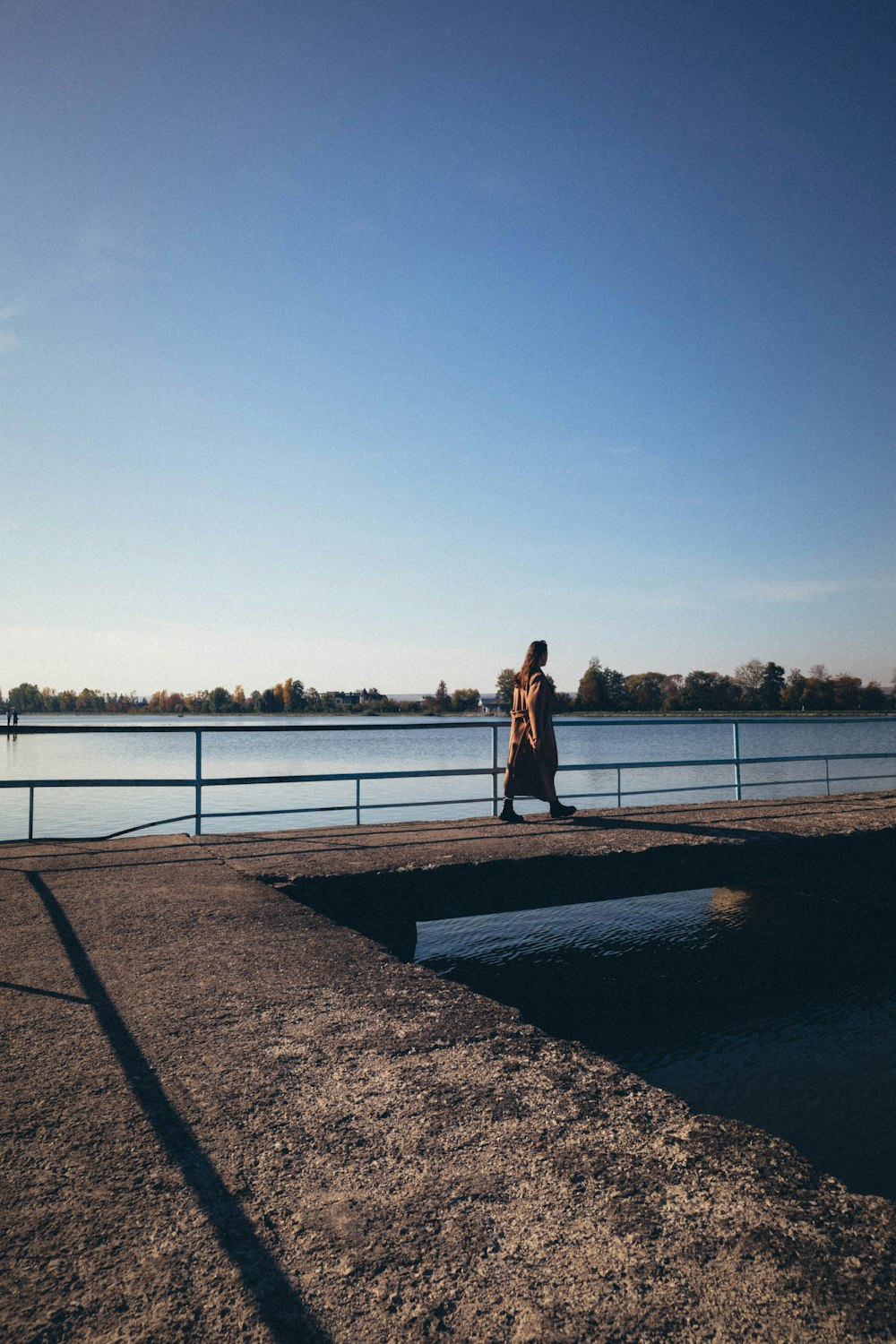 a person standing on a path by a body of water