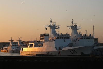 Sunset view of multiple vessels docked at a bustling port.