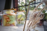 A vibrant candy buffet table adorned with pastel jars and elegant signage at a wedding reception.