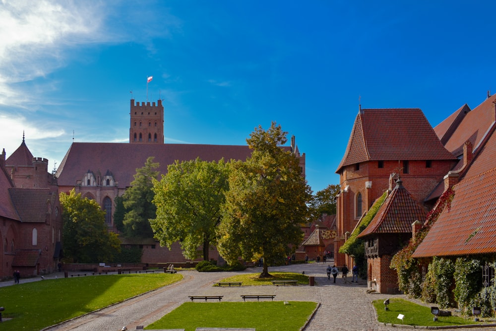 a large brick building with a green lawn and trees in front of it