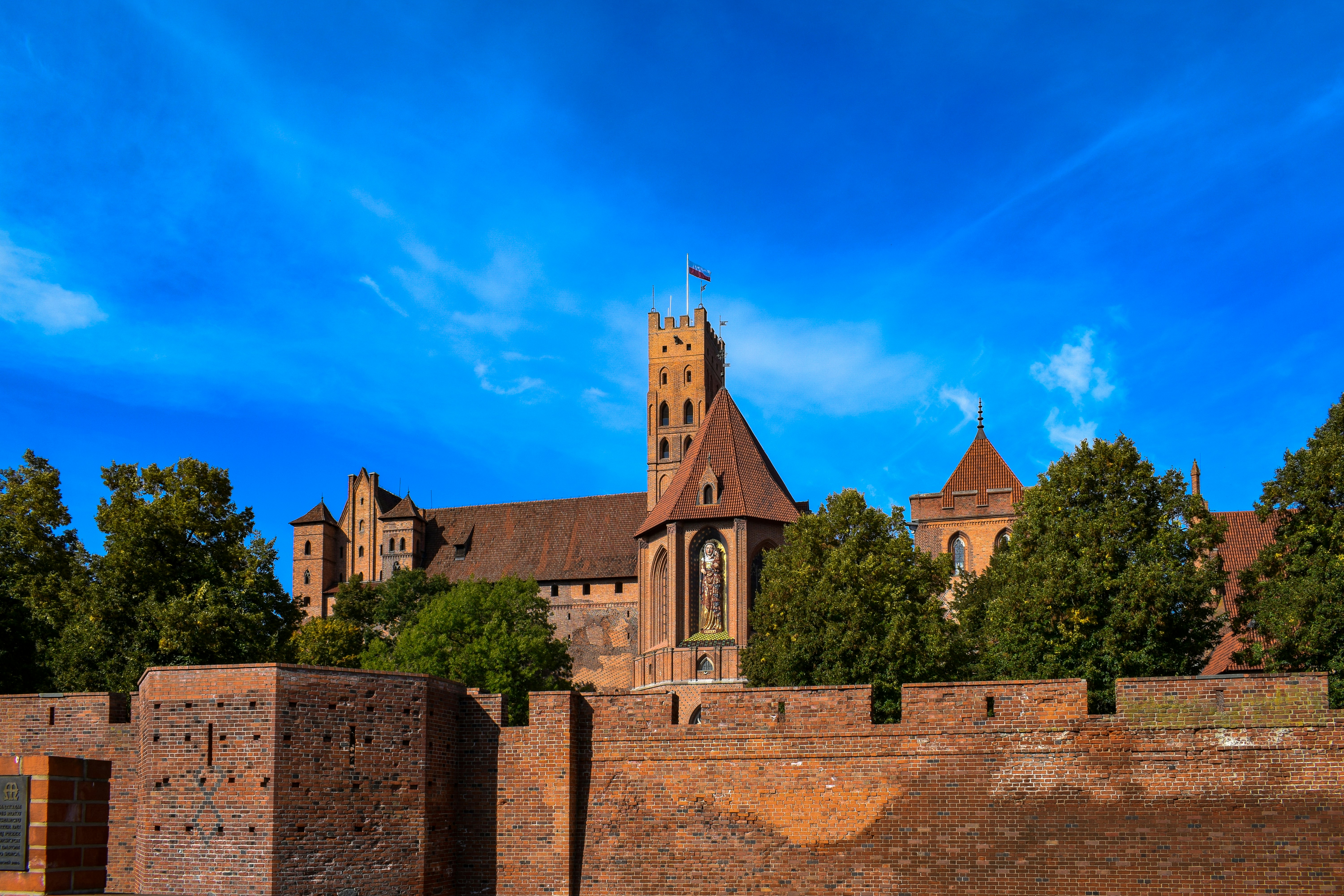 a brick wall with a brick wall and a brick wall with a building in the background