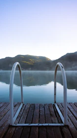a wood deck with a body of water in the background