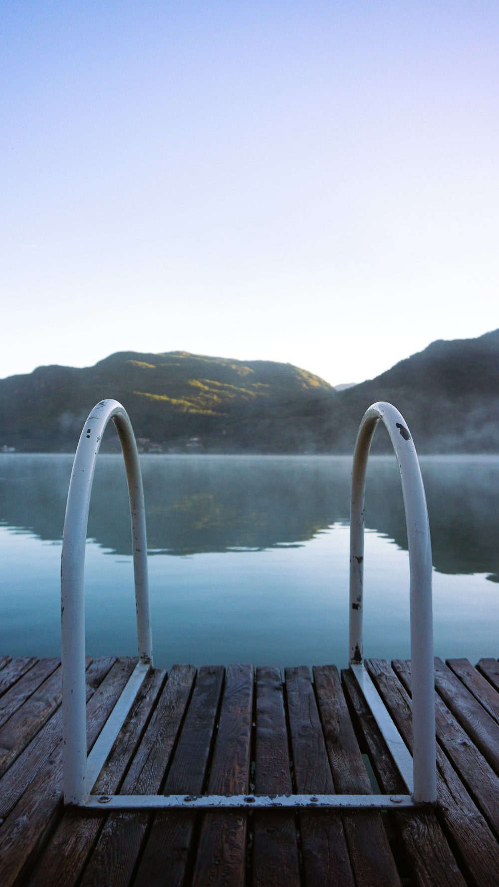 a wood deck with a body of water in the background