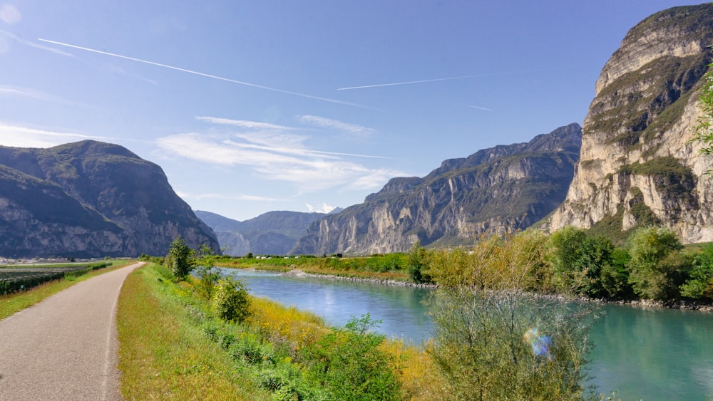 a road next to a body of water with mountains in the background